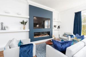 a living room with white furniture and a blue wall at Granby Gem: Exquisite 3-Bed Flat in Harrogate