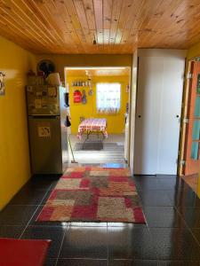 a kitchen with yellow walls and a rug on the floor at Casa Mía Blue 2 in Chillán