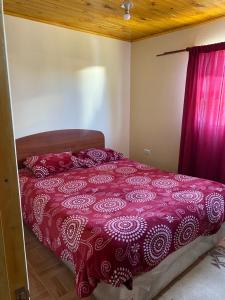 1 dormitorio con 1 cama con edredón rojo en Casa Mía Blue 2, en Chillán