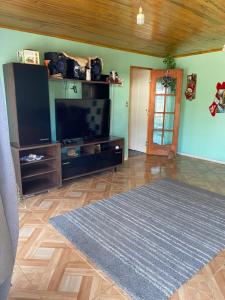 a living room with a flat screen tv and a rug at Casa Mía Blue 2 in Chillán