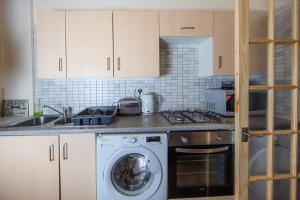a kitchen with a washing machine and a sink at Colourful&Bright Apartment by Carlton Hill in Edinburgh