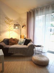 uma sala de estar com um sofá em frente a uma janela em Le Patio 4*. SPA, jardin, piscine en provence, proche Grignan em Saint-Paul-Trois-Châteaux