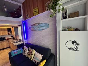 a living room with a couch and a brick wall at T1bis à La Hume climatisé in Gujan-Mestras