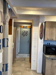 a hallway with a blue door and a kitchen at T1bis à La Hume in Gujan-Mestras
