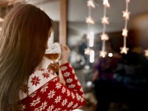 una jovencita comiendo un donut delante de un árbol de Navidad en Apartament widokowy z jacuzzi i sauną na wyłączność - Sikorówka - Dobre Miejsce, en Wisła