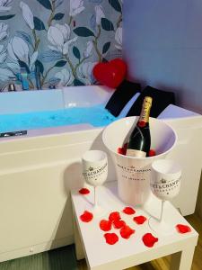uma garrafa de champanhe e duas taças de vinho com corações em DreamHouse Circeo em Borgo Montenero