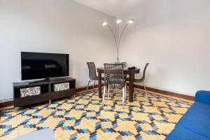 uma sala de estar com uma mesa e cadeiras e uma televisão em MyHouseSpain - Céntrico y luminoso piso em Gijón