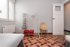 um quarto com uma cama, uma cadeira e uma porta em MyHouseSpain - Céntrico y luminoso piso em Gijón