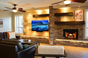 sala de estar con chimenea y TV en Lakeside Luxury Val Vista, en Gilbert