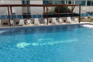 a large swimming pool with chairs and a building at Apartamento laguito vista al mar in Cartagena de Indias
