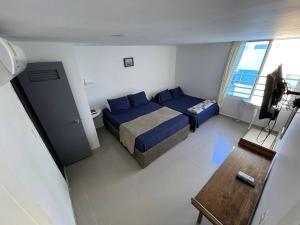 um quarto com uma cama, uma televisão e uma mesa em Apartamento laguito vista al mar em Cartagena das Índias