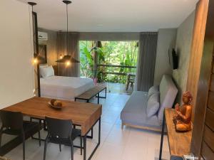 Sala de estar con cama y mesa de comedor en Prime Villas do pratagy en Maceió