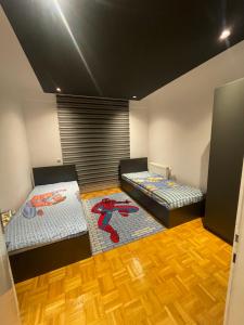Duas camas num quarto com pisos em madeira em Sonny’s Penthouse em Gnjilane