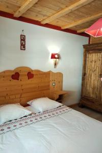 um quarto com uma cama grande e uma cabeceira em madeira em Gte Le Grenier du Roc dans son cadre de verdure em Thiéfosse
