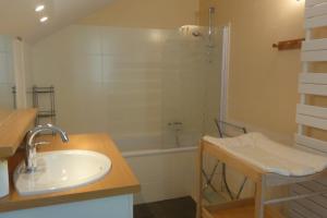 uma casa de banho com um lavatório, um chuveiro e uma banheira em Gte Le Grenier du Roc dans son cadre de verdure em Thiéfosse