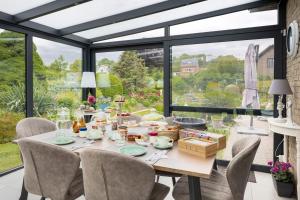 Bassenge的住宿－B&b La Villa Orchidées, breakfast included，一间带桌椅和大窗户的用餐室
