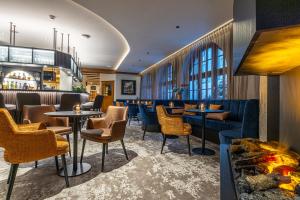 un bar con mesas, sillas y chimenea en Central Apartments Davos, en Davos