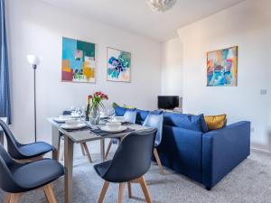 a living room with a blue couch and a table and chairs at Ferry House - HUGE spacious home, FREE PARKING & WIFI in North Shields