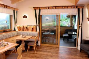 restauracja ze stołem, krzesłami i oknem w obiekcie Familienbauernhof Christa w mieście Rossleithen