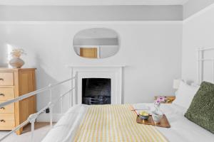 a white bedroom with a bed with a tray on it at Higher Cottage with Parking in Dartmouth