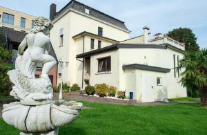 a statue of a woman sitting on a bird bath in front of a house at City Villa - perfect for bigger groups in Goch