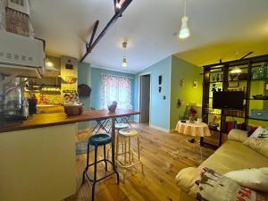 sala de estar con cocina y bar con taburetes en Casa Rural de La Vega, en El Campo