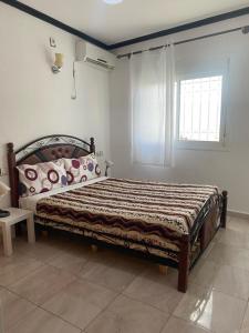 una camera con un letto in una stanza con una finestra di Casa Abdou a Chefchaouen