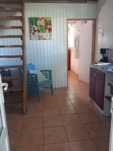 Zimmer mit einer Küche mit einem Tisch und einem Kühlschrank. in der Unterkunft studio dans un écrin vert in Saint-Claude