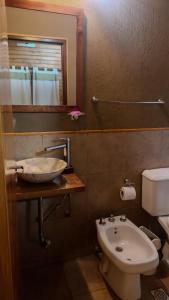 ein Badezimmer mit einem Waschbecken, einem WC und einem Spiegel in der Unterkunft Cabañas Brizas del Norte in San Ignacio