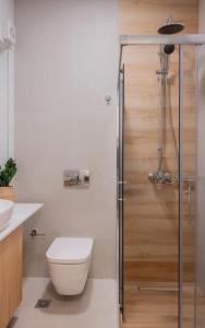 a bathroom with a toilet and a glass shower at Boutique 27, luxury apartment. in Ioannina