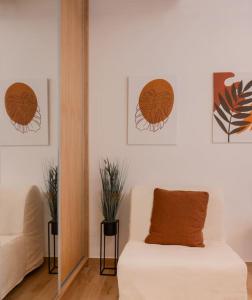 uma sala de estar com um sofá e pinturas na parede em Boutique 27, luxury apartment. em Ioannina