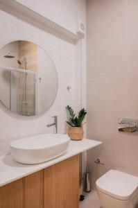 uma casa de banho com um lavatório, um WC e um espelho. em Boutique 27, luxury apartment. em Ioannina