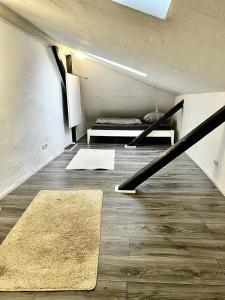 een zolderkamer met 2 bedden en een trap bij Alte Backstube - Kaiserslautern in Kaiserslautern