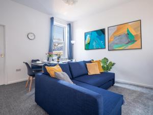 a living room with a blue couch and a table at Ferry House - HUGE spacious home, FREE PARKING & WIFI in North Shields