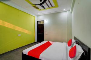 1 dormitorio con 1 cama y techo verde en OYO Flagship J M K Love Residency en Noida