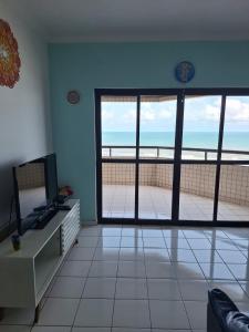 Bela Vista Praia Grande في Solemar: غرفة معيشة مطلة على الشاطئ