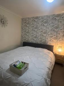 een slaapkamer met een bed met een koffer erop bij SuperKing Bed Free Parking Internet Garden Patio TV Quiet Close to main bus route B98 9NH in Beoley