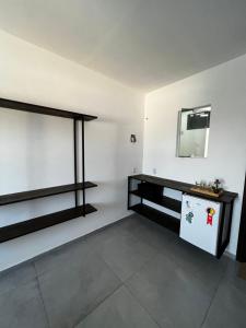 フロリアノポリスにあるPousada Tamatoaの白い壁と黒い棚の部屋