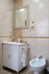 uma casa de banho com um lavatório, um WC e um espelho. em Infinity Boutique Apartments em Bansko