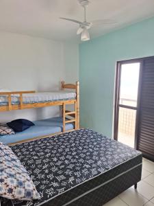 1 dormitorio con 2 literas y ventilador de techo en Bela Vista Praia Grande en Solemar