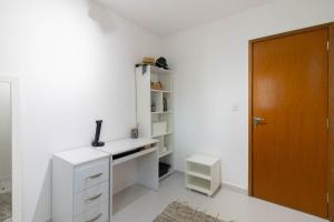 a room with a white desk and a brown door at Cobertura 2 quartos Tucuruvi in Sao Paulo