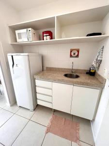 uma pequena cozinha com um lavatório e um frigorífico em V321 Flat aconchegante em área central em Brasília