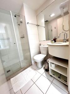 uma casa de banho com um chuveiro, um WC e um lavatório. em V321 Flat aconchegante em área central em Brasília
