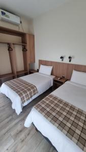 twee bedden in een hotelkamer met twee bedden bij Vistara Suites in Iquique