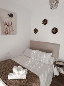 Un dormitorio con una cama blanca con una foto en la pared en Casa Blanca en Sevilla