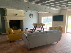 a living room with couches and a fireplace at L'étape de Marcel - Zanini in Avoine