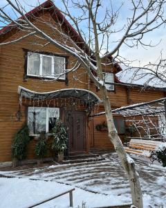 a house with snow on the front of it at Марічка Marichka in Vorokhta