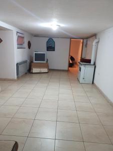 a large room with a tiled floor and a television at Apartman SM IK in Tomislavgrad
