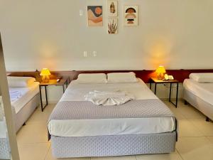 1 dormitorio con 2 camas y 2 lámparas en Hotel Monalisa en Foz de Iguazú