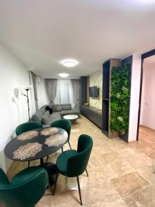 sala de estar con 2 mesas y sillas verdes en Boutique Apartment DOLCHE VITA, en Smolyan